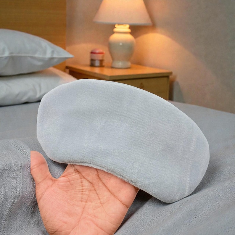 Pu&ograve; includere: Una mascherina per dormire grigio chiaro realizzata in materiale morbido. La mascherina &egrave; tenuta in mano ed &egrave; progettata per bloccare la luce e favorire il sonno. La mascherina &egrave; di colore uniforme e ha una forma curva per adattarsi ai contorni del viso.