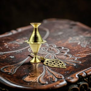 May include: A set of three ceramic mugs with a speckled, matte finish. The mugs are in shades of cream, light gray, and dark gray. Each mug has a simple, minimalist design and a rounded handle.