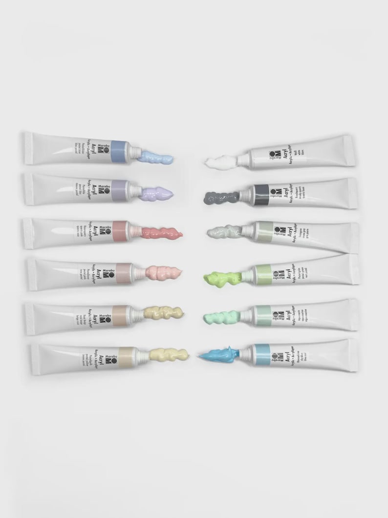 May include: An assortment of twelve tubes of acrylic paint, each with a different color extruded from the tip. The paint colors include shades of blue, purple, pink, red, white, gray, green, yellow, and beige. The tubes are white with black text.