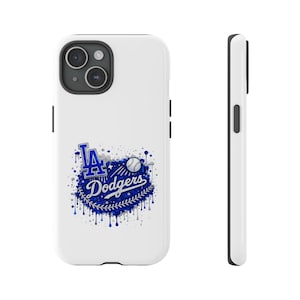 Könnte beinhalten: Weißes Handycase mit dem Logo der Los Angeles Dodgers in Blau und Weiß. Das Design beinhaltet den Teamnamen und einen Baseball mit einem Spritzeffekt. Das Case wird von vorne und von der Seite gezeigt.