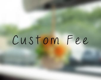 Może przedstawiać: Rozmyty obraz z napisem Custom Fee czcionką bezszeryfową w kolorze czarnym, wyśrodkowany na miękkim, nieostrym tle z nutami pomarańczowych i żółtych kształtów kwiatowych oraz zielonych liści, sugerujący dekoracyjny przedmiot wiszący.