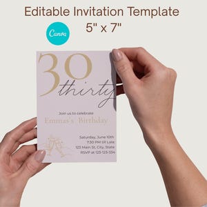 Puede incluir: Una plantilla de invitación de cumpleaños rosa claro, 12,7 cm x 17,8 cm, sostenida por manos. El diseño presenta texto dorado que dice "30 thirty" y "Emma's Birthday". Incluye detalles del evento y un logotipo de Canva.