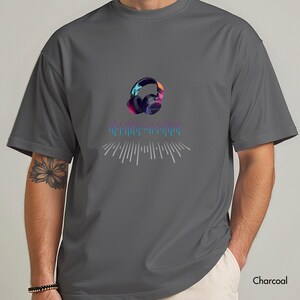 May include: Charcoal gray t-shirt featuring a colorful graphic of headphones and sound waves. The headphones have a gradient of colors, including purple, blue, and orange. The text "Charcoal" is printed at the bottom right.