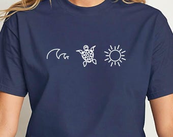 Könnte beinhalten: Marineblaues T-Shirt mit weißer Grafik einer Welle, einer Meeresschildkröte und einer Sonne. Das Shirt besteht aus einem weichen Material und hat einen klassischen Rundhalsausschnitt. Das Wort "Navy" ist unten rechts aufgedruckt.