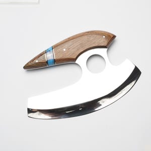 A wooden and silver knife with a curved blade and a blue and silver decorative accent on the handle.
