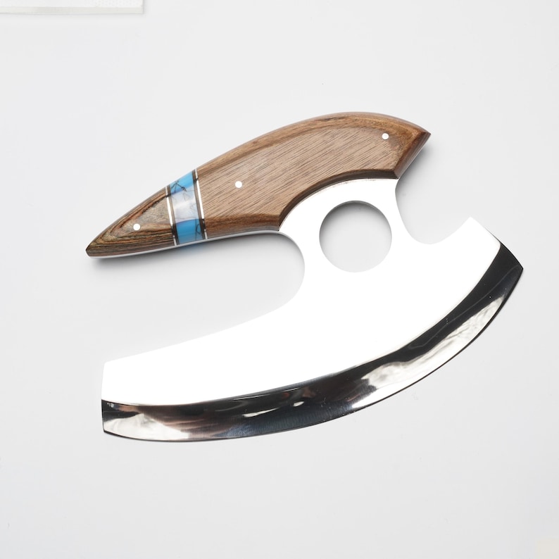 A wooden and silver knife with a curved blade and a blue and silver decorative accent on the handle.