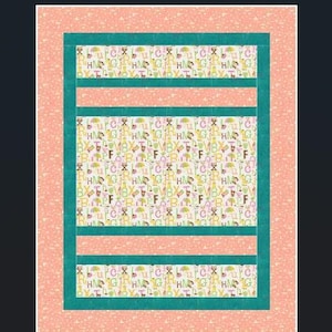May include: A rectangular quilt with a peach-colored border and teal green inner borders. The central panels feature a repeating pattern of letters, umbrellas, and other small graphics on a cream background. Horizontal peach stripes add visual interest.