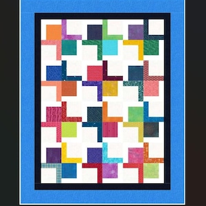 May include: A colorful quilt with a repeating pattern of squares and crosses. The quilt features a variety of fabrics in shades of orange, green, blue, purple, and red, set against a white background. The quilt is framed with a blue border.