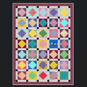 May include: A colorful patchwork quilt with a repeating pattern of squares and diamonds. The quilt features a variety of fabrics in shades of red, blue, yellow, pink, and green. The quilt is framed with a red and white dotted border.