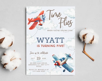 May include: A blue and white airplane with red accents flies through the clouds. The text "Time Flies" is written in brown script. The text "When you're having fun!" is written in smaller brown script. The text "Wyatt is turning five!" is written in blue script. The text "Join us to celebrate" is written in brown script. The date "Oct. 19 2PM" is written in brown script. The address "85 Red Oak Drive, Greenhills, Any City 54321" is written in brown script. The text "RSVP to: Mikaela at 777-444-4321" is written in brown script.