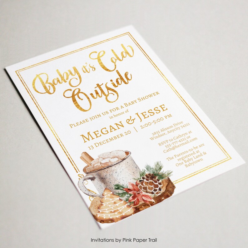 May include: A white rectangular baby shower invitation with a gold foil border and gold text reading Baby it's Cold Outside. It features a watercolor illustration of a mug with marshmallows, a pinecone, and a decorated cookie.