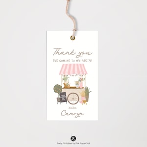 May include: A white gift tag with a watercolor illustration of a pink and white striped flower cart. The tag reads "Thank you for coming to my party!" and includes the name "Camryn". A small sign says "Fresh Flowers for Sale".