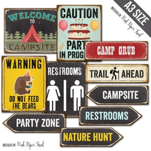 May include: A collection of vintage-style metal signs with various camping and party-themed messages. Signs include "Welcome to Campsite," "Caution Party in Prog," "Camp Grub," "Warning Do Not Feed the Bears," and directional signs.