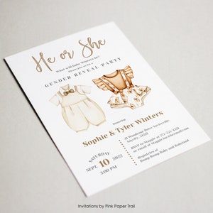 May include: He or She Gender Reveal Party invitation with a brown and white illustration of a baby outfit for a boy and a baby outfit for a girl. The invitation includes the date, time, and location of the party, as well as the names of the parents-to-be, Sophie and Tyler Winters.