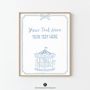 May include: A framed print with a light blue carousel illustration on a white background. The print includes the text "Your Text Here" in a script font, and a decorative bow at the top. The frame is a light wood colour.