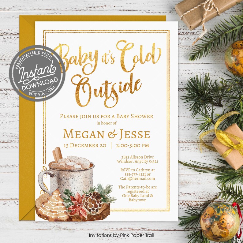 May include: A white baby shower invitation card with gold foil-style text reading Baby it's Cold Outside, featuring a watercolor illustration of a mug with marshmallows, a gingerbread cookie, and a pinecone, set against a mustard yellow envelope.