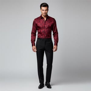 May include: A formal outfit featuring a burgundy button-down shirt with a floral pattern and black dress pants. The long-sleeved shirt is paired with a black belt and dress shoes. The outfit is suitable for special occasions.