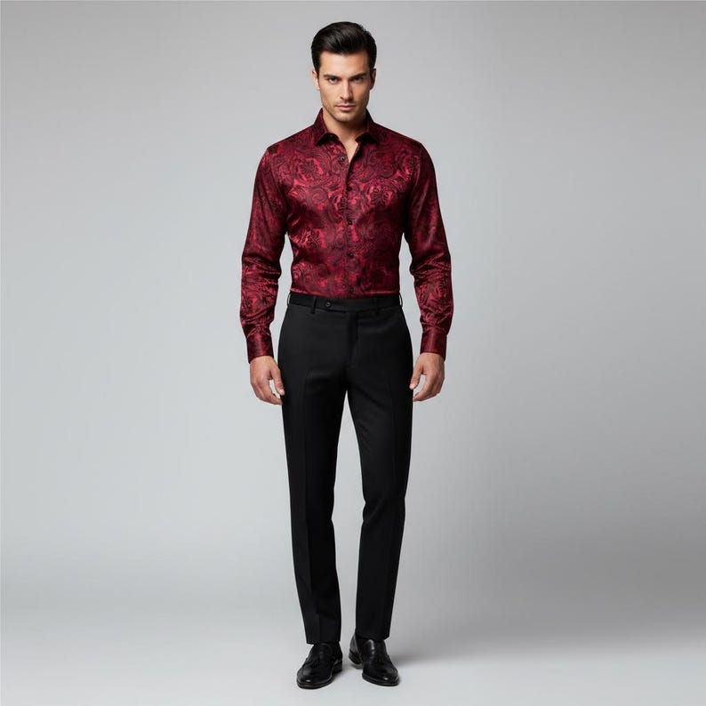 May include: A formal outfit featuring a burgundy button-down shirt with a floral pattern and black dress pants. The long-sleeved shirt is paired with a black belt and dress shoes. The outfit is suitable for special occasions.