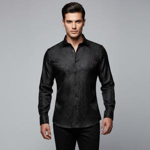 May include: A black long-sleeve shirt with a subtle paisley pattern. The shirt has a classic collar and button-down front. The fabric appears to have a slight sheen, adding to its formal appearance. The shirt is paired with black pants.