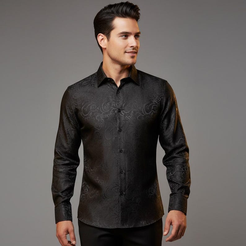 May include: Black long-sleeve button-down shirt with a subtle paisley pattern. The shirt has a classic collar and buttoned cuffs. The fabric appears to have a slight sheen.