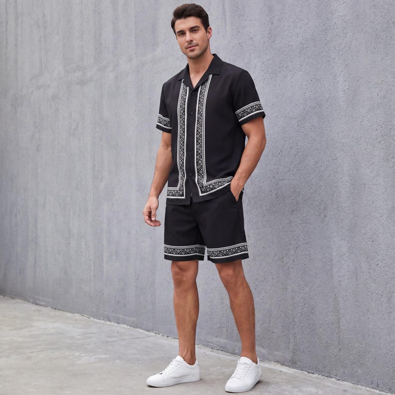 May include: Black short-sleeve shirt and shorts set with white geometric trim. The shirt has a collared neckline and button-down front. The shorts have a matching trim at the hem. The model is wearing white sneakers.