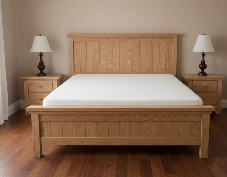 May include: A light-colored wooden bed frame with a matching headboard and footboard. The bed has a white mattress and is flanked by two matching nightstands with lamps. The room has a neutral color palette.
