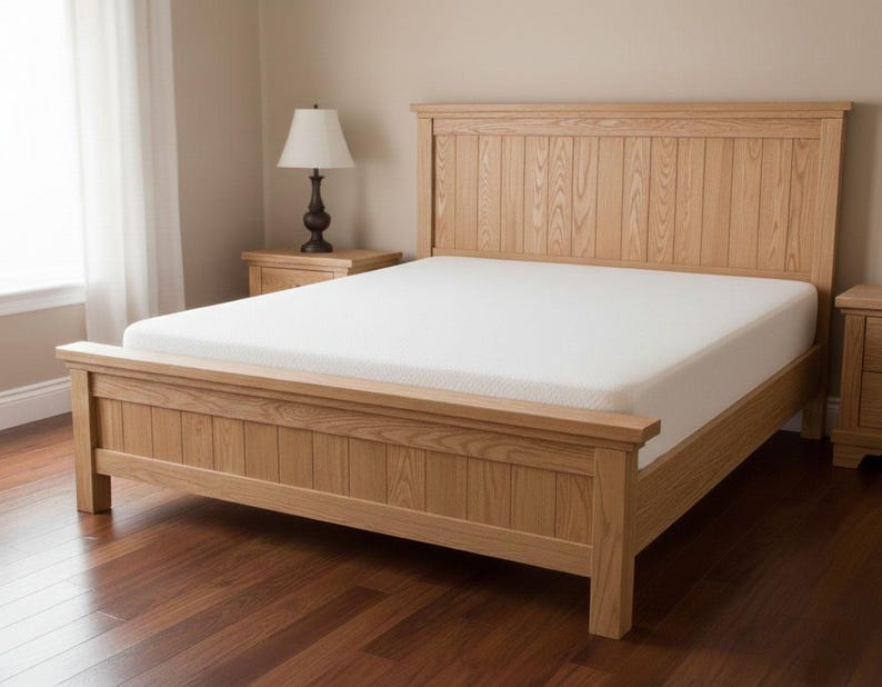 May include: A light-colored wooden bed frame with a matching headboard and footboard. The bed has a white mattress and is set in a room with a window and a bedside table with a lamp.