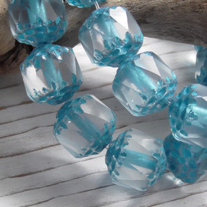 Pode incluir: Um fio de contas de vidro facetadas de cor azul claro com acabamento fosco. As contas s&atilde;o facetadas e t&ecirc;m um brilho ligeiramente iridescente.