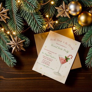 May include: A festive holiday invitation for a Secret Santa party, featuring a cocktail illustration with a candy cane. The invitation is on a cream-colored card, surrounded by Christmas ornaments, pine branches, and fairy lights.