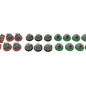 May include: A collection of miniature game pieces in various shapes and colors. There are gray structures with red bases, gray circular pieces with black bases, and gray structures with green bases. The pieces are arranged on a white background.
