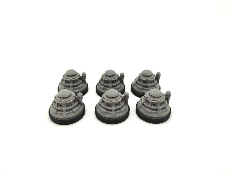 May include: Six gray, miniature, tiered structures with a rounded top and a black base are arranged on a white background. Each structure has a detailed, architectural design, suggesting a model or decorative item.