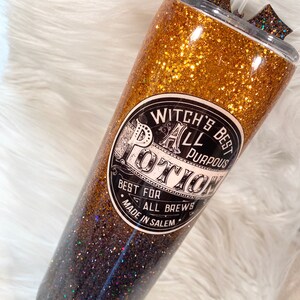 May include: Glittery tumbler with a gold and black ombre design. The tumbler features a label that reads "Witch's Best All Purpous Potion, Best for All Brews, Made in Salem". Includes a straw and decorative accents.