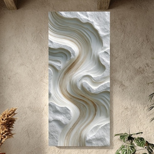 May include: Abstract wall art with a flowing design in white and gold tones. The artwork has a textured, three-dimensional appearance, reminiscent of carved stone or layered materials. It is displayed in a well-lit, modern interior setting.