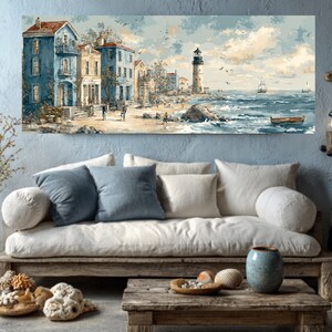 May include: Coastal landscape painting featuring a seaside town with blue buildings, a lighthouse, and a sailboat on the ocean. The artwork has a vintage aesthetic with muted colors and a serene atmosphere. The painting is displayed above a wooden sofa with pillows.