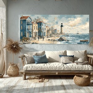 May include: Coastal landscape painting featuring buildings in shades of blue and yellow, a lighthouse, and a sailboat on the sea. The artwork is displayed above a wooden sofa with pillows and a woven basket, creating a serene, nautical-themed interior.