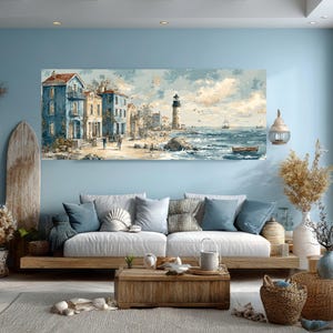May include: Coastal-themed artwork depicting a seaside town with blue buildings, a lighthouse, and a beach. The painting is displayed above a white sofa with blue pillows, complemented by a wooden coffee table and decorative elements, creating a serene living room setting.