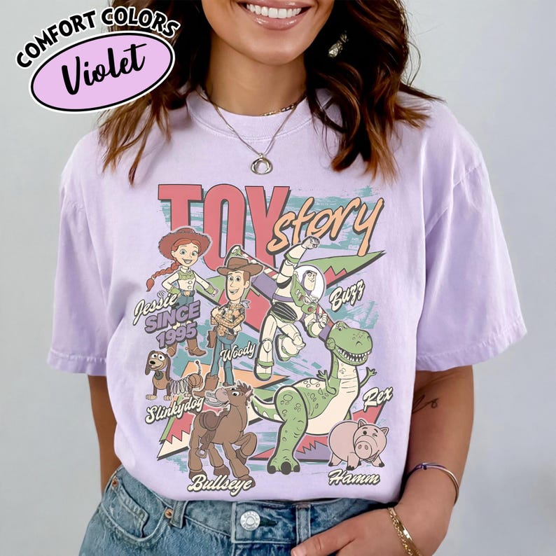 May include: Violet Comfort Colors t-shirt featuring a Toy Story graphic. The design includes characters like Woody, Buzz Lightyear, and Rex. The text "Toy Story" is prominently displayed, along with "Jessie Since 1995".