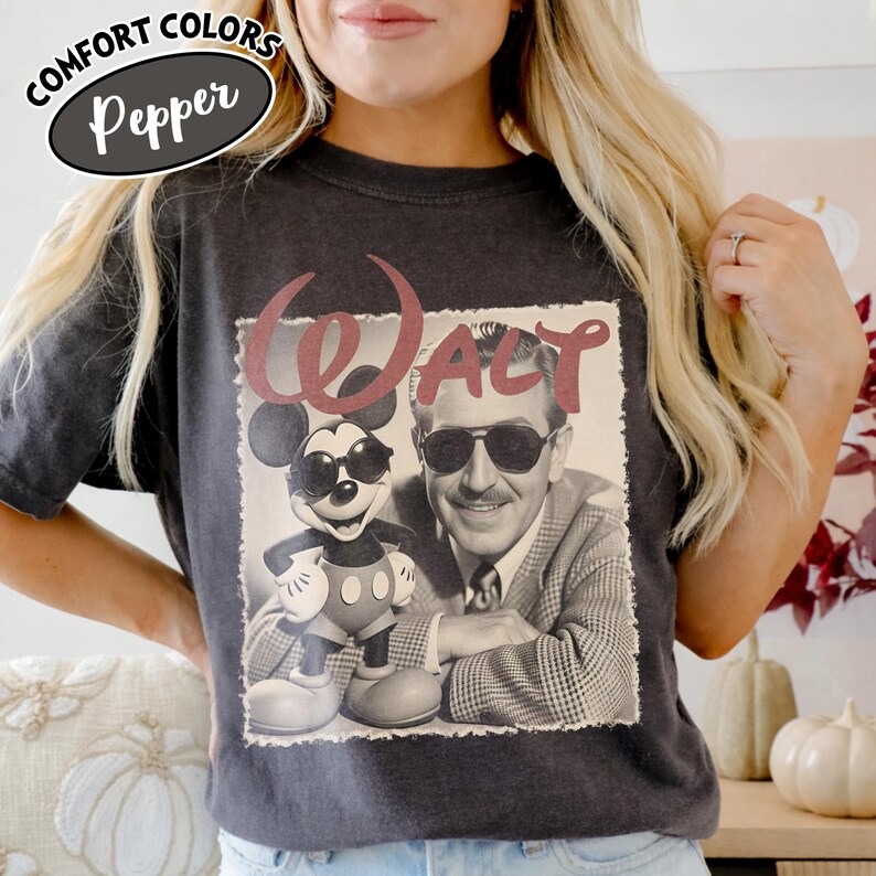 May include: Dark gray t-shirt featuring a vintage-style graphic of Mickey Mouse and Walt Disney, with the word "WALT" in maroon. The shirt has the words "COMFORT COLORS" and "Pepper" printed on the top.