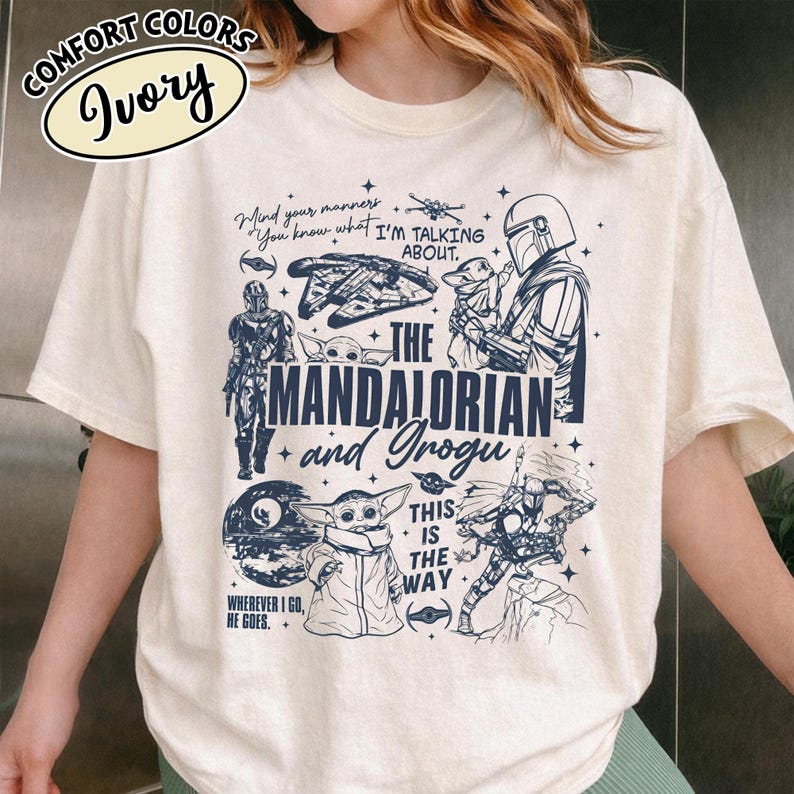 Op de afbeelding: Ivoor T-shirt met een grafisch ontwerp uit de serie "The Mandalorian". Het ontwerp bevat personages, ruimteschepen en de tekst "This is the Way". Het shirt is gemaakt van Comfort Colors materiaal.