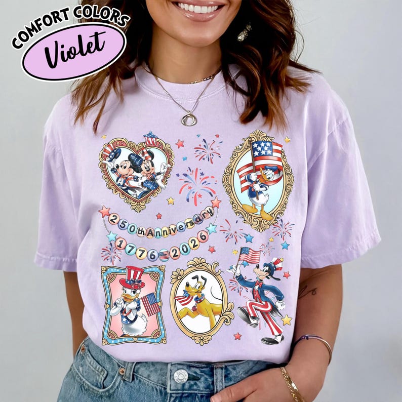 May include: A violet Comfort Colors t-shirt featuring framed cartoon characters in patriotic attire. The shirt includes Mickey and Minnie Mouse, Donald Duck, Pluto, and Goofy, with fireworks and the text "250th Anniversary 1776-2026."