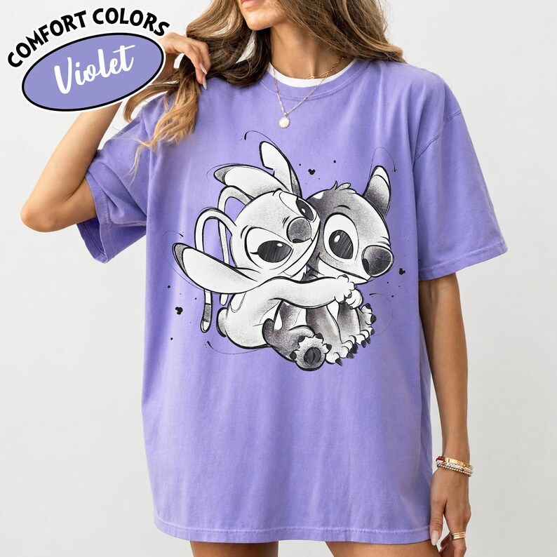 May include: Violet Comfort Colors t-shirt featuring a black and white graphic of two cartoon characters embracing. The shirt has short sleeves and a crew neck. The text "COMFORT COLORS" and "Violet" are in a purple oval on the top left.