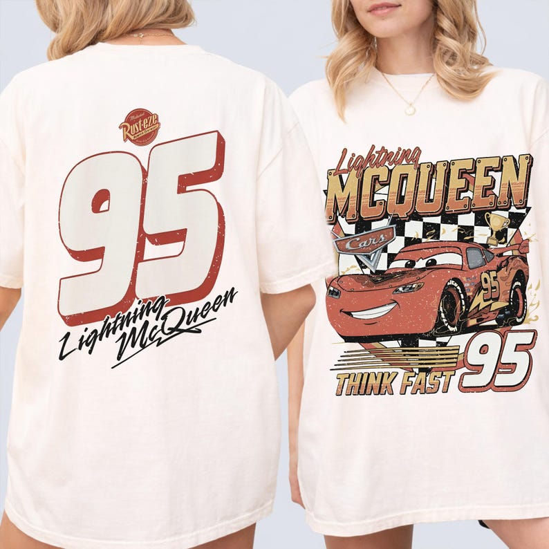 May include: Off-white t-shirts featuring Lightning McQueen from the Cars movie. One shirt displays a large number 95 with "Lightning McQueen" text. The other shirt shows Lightning McQueen with "Think Fast" text.