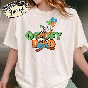 May include: A white ceramic mug with a black handle and the text "But First, Coffee" in a black, handwritten-style font. The mug is on a white surface.