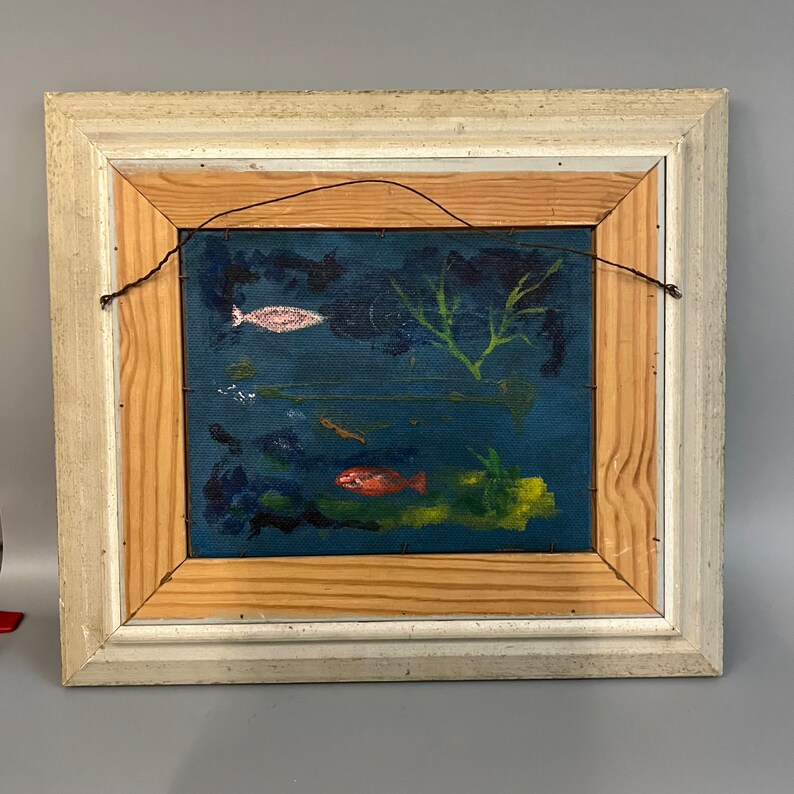 May include: A framed painting of a blue underwater scene with fish and seaweed. The fish are painted in shades of pink, orange, and red.