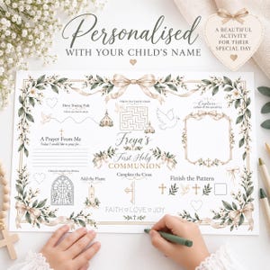 Può includere: Un foglio di attività bianco per la Prima Comunione con bordo floreale e nastri, un labirinto, una sezione per la preghiera, una vetrata da colorare e il testo Freya's First Holy Communion, Faith, Love, Joy, Capture a photo.