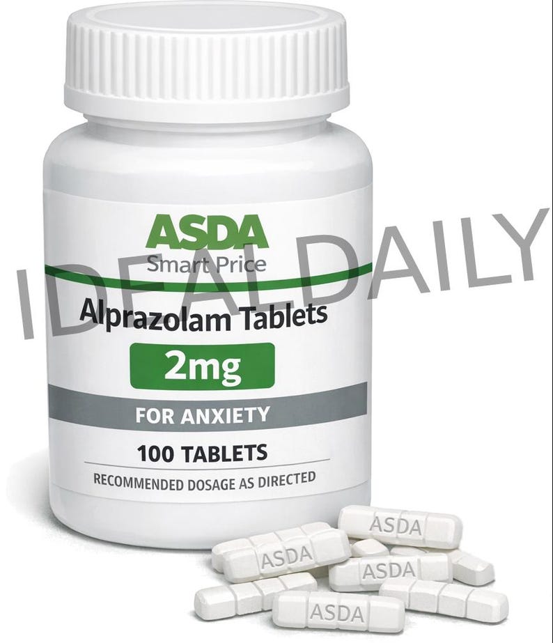 Op de afbeelding: Een witte plastic fles ASDA Alprazolam Tabletten, 2mg, voor angst. Het etiket geeft 100 tabletten en de aanbevolen dosering aan. Verschillende witte pillen met "ASDA" zijn verspreid in de buurt van de fles.