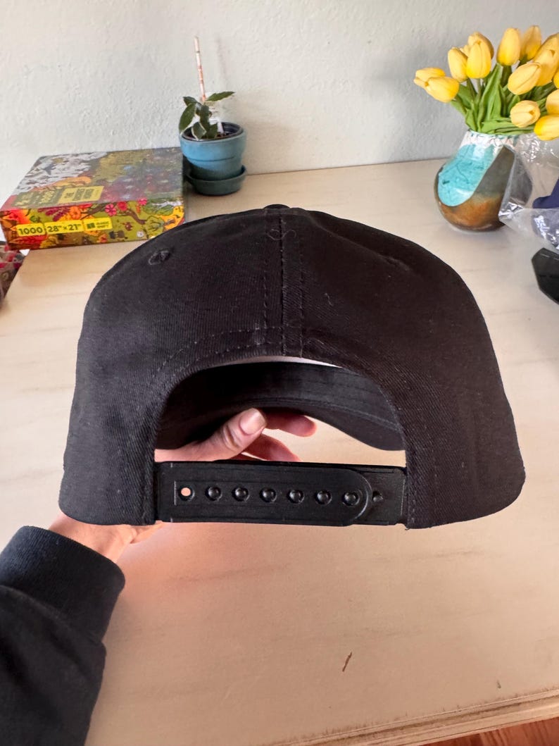Pode incluir: Bon&eacute; de beisebol preto com aba curva e fecho de press&atilde;o ajust&aacute;vel. O bon&eacute; &eacute; feito de tecido preto liso e apresenta uma coroa estruturada. O fecho de press&atilde;o permite um ajuste personalizado.