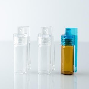 May include: Several small glass bottles with clear and amber bodies, and blue and clear caps. The bottles are presented against a white backdrop, highlighting their design and shape. The bottles are likely for essential oils.