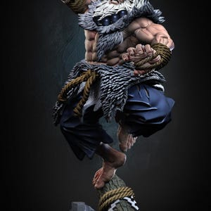 Puede incluir: Figura detallada de un guerrero musculoso con cabello blanco y expresión feroz. La figura está vestida con pantalones azules y ropa con adornos de piel, con detalles de cuerda. El guerrero está posando en plena acción, de pie sobre un tronco.