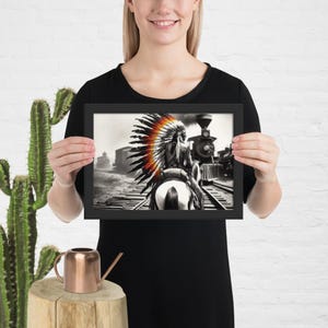 Poster incorniciato in carta opaca con tema Far West e ferrovia che raffigura un indiano a cavallo che combatte per preservare la sua terra.